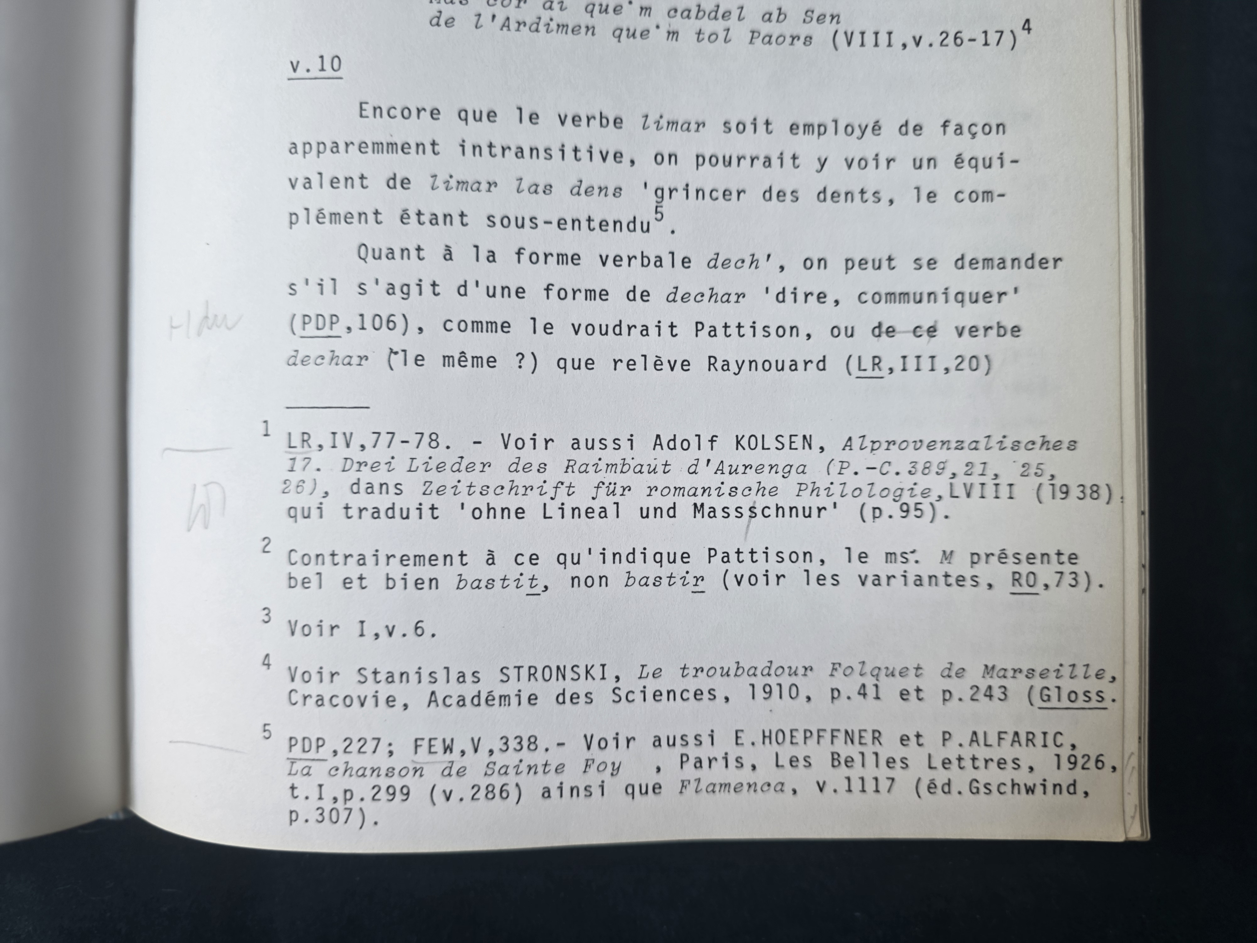 A typewritten page fragment in French with true italic type, a word corrected by hand in ink, and an underlined abbreviation.